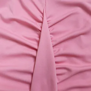Gedetailleerde macro-opname van roze geplooide stretchstof met rimpeldetails