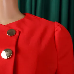 Close-up of red elegant top with large gold buttons and puff sleeve texture details.