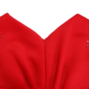 Detail shot of red V-neck evening dress featuring fine invisible zipper and beads.