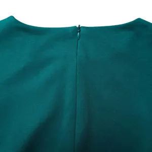 Vue détaillée d'une robe à col rond avec une fermeture éclair invisible au dos en bleu-vert foncé.
