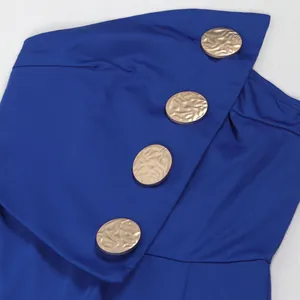 Detailaufnahme des blauen trägerlosen Jumpsuits mit dekorativen Goldknöpfen