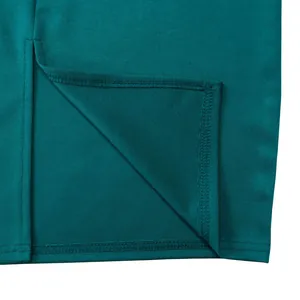 Détail de la robe crayon bleu sarcelle montrant l'ourlet fendu et la couture