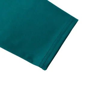 Gros plan sur un tissu en maille sarcelle avec surpiqûres à double aiguille nettes.