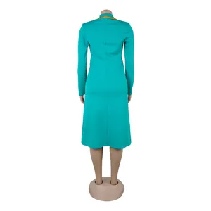 Back view of an elegant teal long-sleeved dress with orange lapel detail on a mannequin