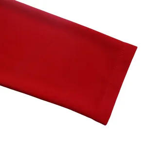 Vue détaillée des coutures fines et de la texture du tissu rouge du revers de manche.