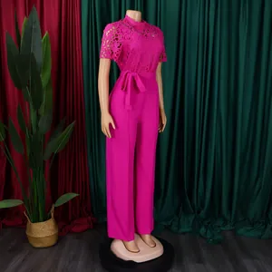 Full view of fuchsia pink lace jumpsuit on mannequin with tied waist and wide legs.