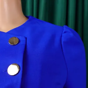 Close-up detail of cobalt blue fashion top with gold buttons and puff sleeves