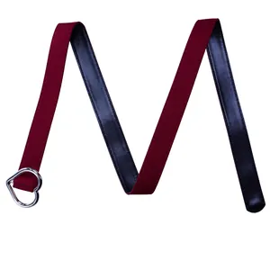 Détail d'une ceinture réversible rouge et noire avec boucle en cœur argentée.