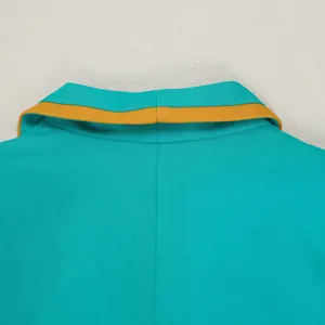 Detailed macro view of a turquoise suit vest collar with a yellow contrast trim edge