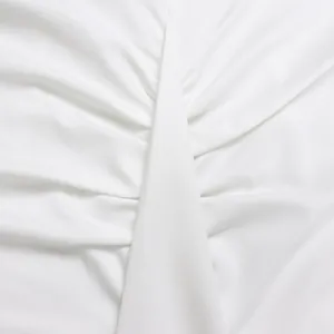 Gedetailleerde macro-opname van witte geplooide stof op een elegante witte kokerjurk