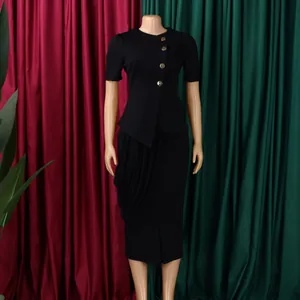 Detailed view of women's elegant black two-piece set with gold buttons and draped skirt.