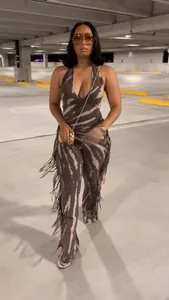 Sexy tie-dye halter jumpsuit with fringe details and flared legs in parking garage