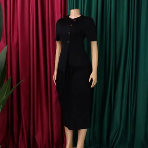 Detail view of black elegant two-piece set featuring a buttoned top and draped skirt