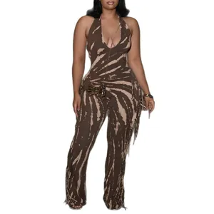 Detail view of a brown tie-dye halter neck jumpsuit with side fringe and flared legs