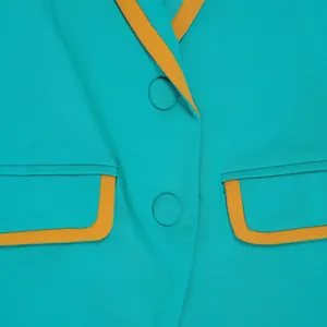 Detailed close-up showing turquoise fabric texture and yellow contrast piping detail.
