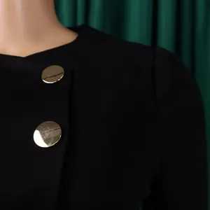 Macro view of elegant black jacket detail featuring two polished gold circular buttons