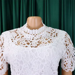 Detailed view of the white floral lace texture and high neckline of the jumpsuit