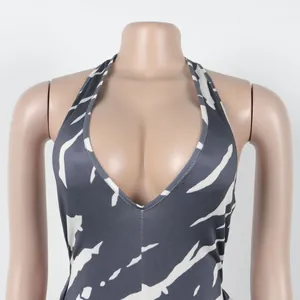 Detailed view of the deep V-neck and marble print on this sexy halter neck jumpsuit