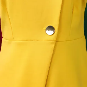 Close-up detail of yellow elegant two-piece suit showing premium silver metal button