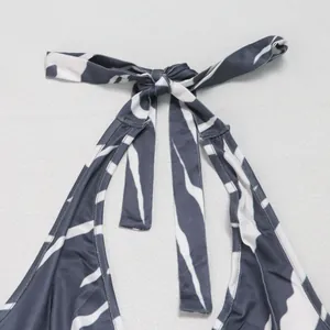 Close-up detail of halter strap tie-neck on grey and white abstract print jumpsuit