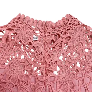 Macro detail view of elegant pink lace hollow-out texture on women's high neck jumpsuit