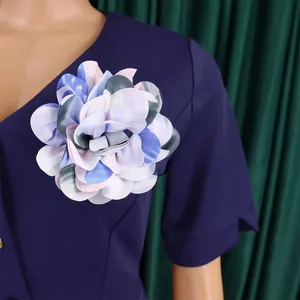 Dettaglio ravvicinato di un grande fiore in tessuto su un abito blu navy africano