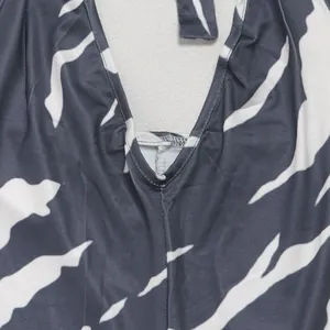 Detailed view of the V-neckline and elastic zebra print fabric of the halter jumpsuit