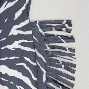 Close-up of the fringe detail and zebra print on this elegant backless jumpsuit