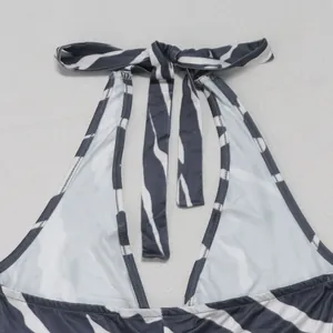 Close-up detail view of zebra print halter neck jumpsuit with adjustable tie neck straps