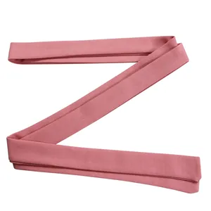 Close-up detail of a soft pink woven fabric belt sash for a women's fashion jumpsuit.