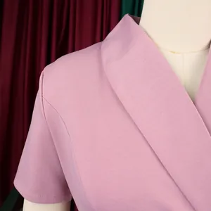 Close-up of pink short-sleeved dress showing lapel collar and textured fabric detail