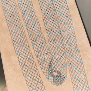 Exquisites Detail einer silberfarbenen Netzkette mit hellblauen runden Perlen