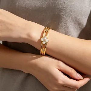 Elegant gold stainless steel bangle featuring crystal inlaid lucky clover design