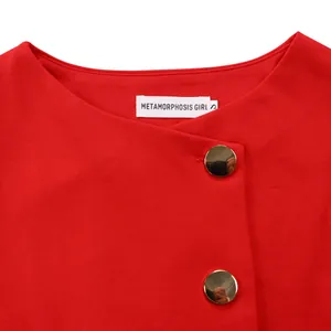 Detail macro view of elegant red top with decorative gold buttons and brand label