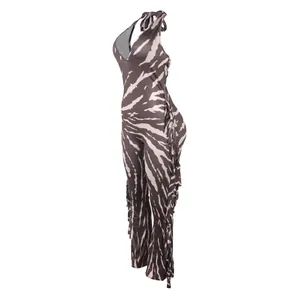 Side view of zebra print halter jumpsuit with fringe details and flared leg.
