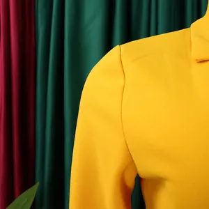 Vue détaillée de l'épaule d'une robe africaine jaune montrant la texture du tissu crêpe.