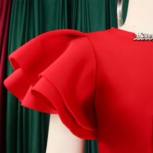 Close-up of red party dress showing ruffle sleeves and rhinestone neckline detail