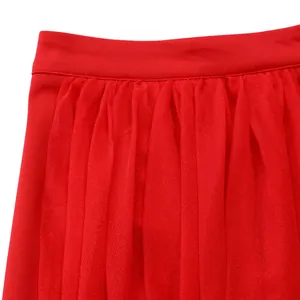 Close-up detail of a vibrant red tulle skirt featuring a pleated elastic waistband