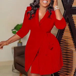 Vue détaillée d'une robe rouge éclatante avec col blazer, jupe plissée et ceinture.