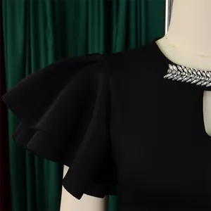 Close-up of black evening dress featuring ruffle sleeves and rhinestone collar detail