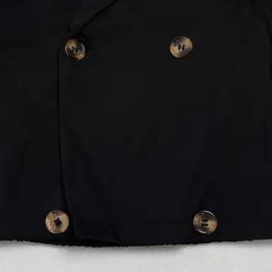 Detailaufnahme der zweireihigen Knöpfe an einem schwarzen Business-Casual-Blazer.
