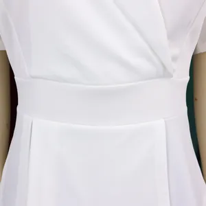 Close-up detail of the waist and neckline of a white short-sleeved African dress