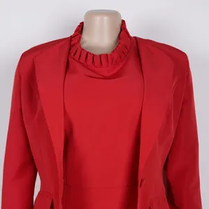Detailaufnahme eines roten Blazers mit Revers und passendem Top mit Faltenkragen