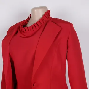 Detail des roten zweiteiligen Anzugs mit Rüschenkragen und klassischem Blazer-Revers.