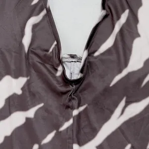 Detail shot of the V-neckline stitching on an abstract tiger print halter jumpsuit