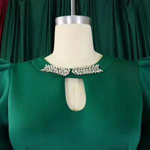 Close-up of emerald green evening dress with elegant silver rhinestone collar detail