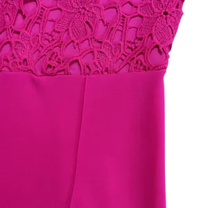 Close-up detail of fuchsia pink jumpsuit showing intricate lace hollow pattern and fabric
