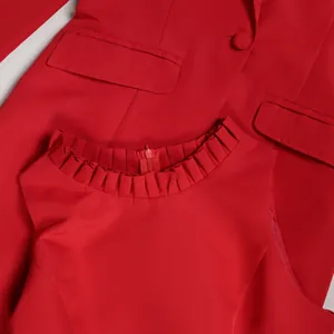 Detailaufnahme eines roten Blazers und Weste mit gerafftem Ausschnitt, Anzugset Stoff.