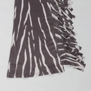 Close-up macro view of the stylish fringe detail and zebra print on jumpsuit leg