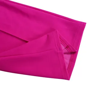 Close-up view of the neatly stitched hemline on a vibrant fuchsia wide-leg jumpsuit